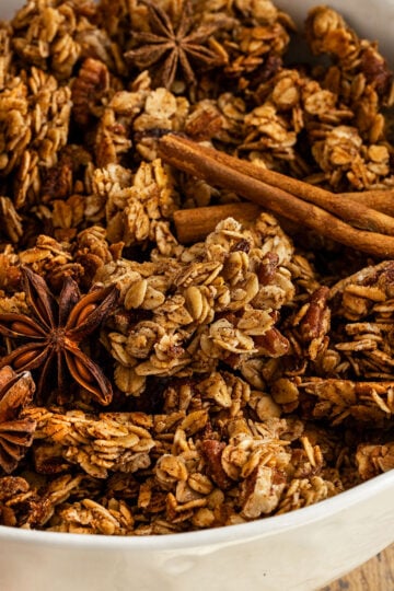 bowl of granola with cinnamon sticks and star anise.