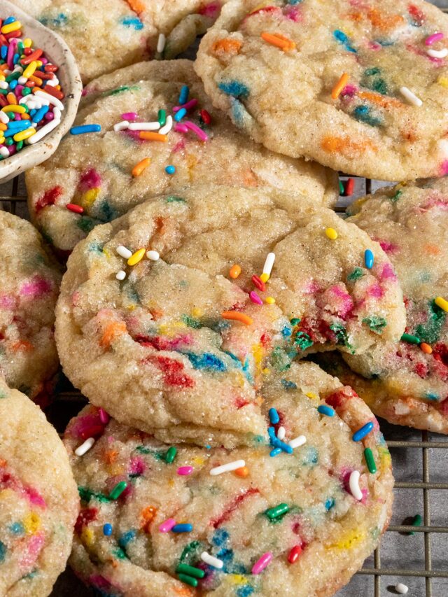 funfetti sugar cookie missing a bite on a baking sheet of cookies.