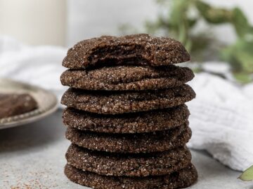 stack of 7 chocolate sugar cookies where the top cookie has a bite taken out of it