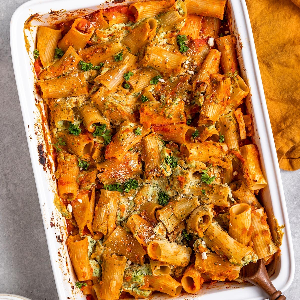a big pan of ziti with tofu ricotta, tomato sauce, and lentils with parsley on top