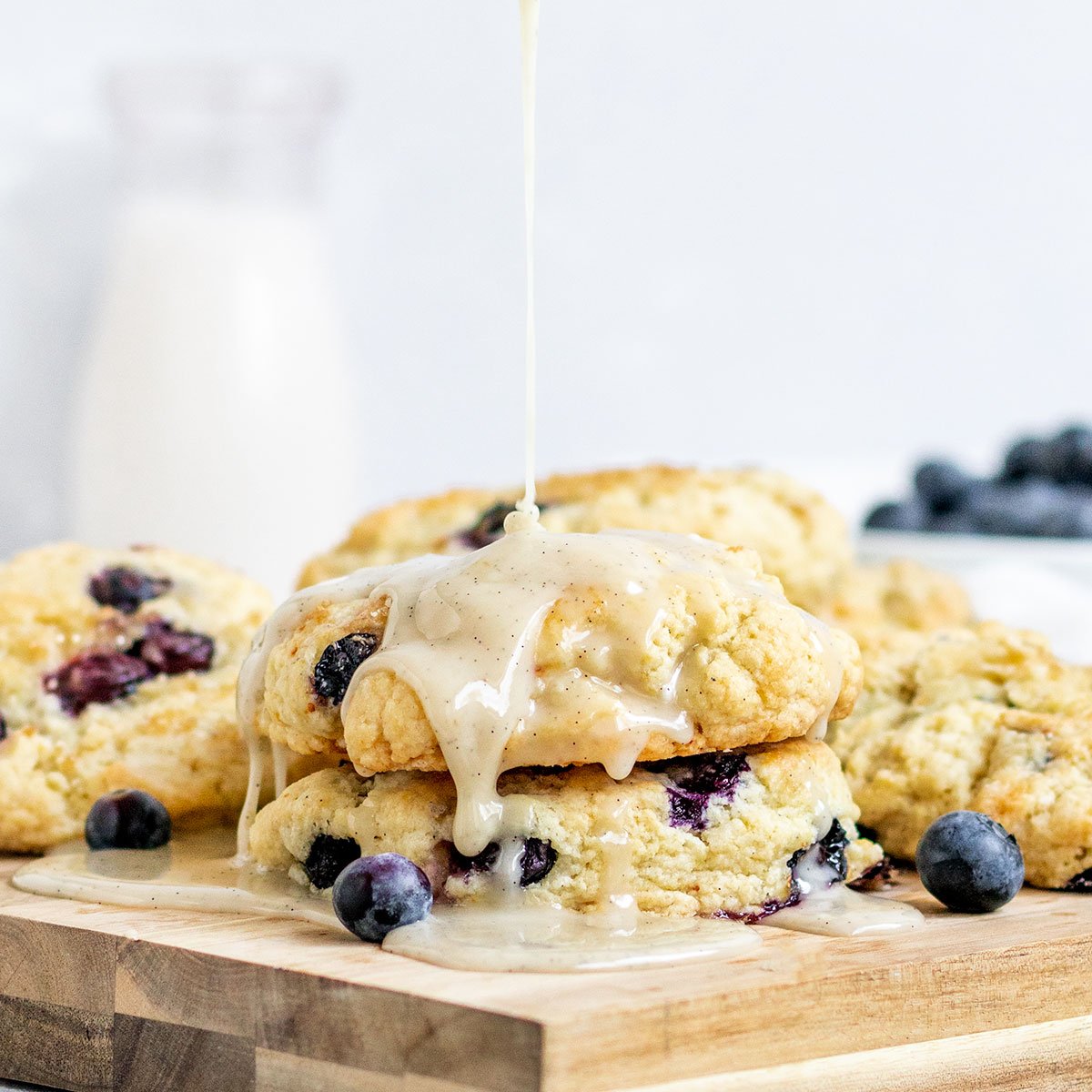glaze being poured onto blueberry scones