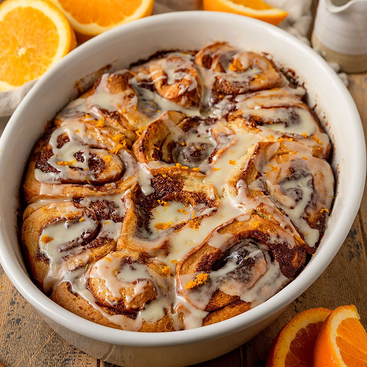 oval baking tray filled with orange cinnamon rolls