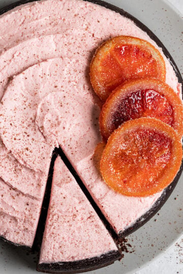 circular chocolate cake with blood orange frosting and candied blood oranges