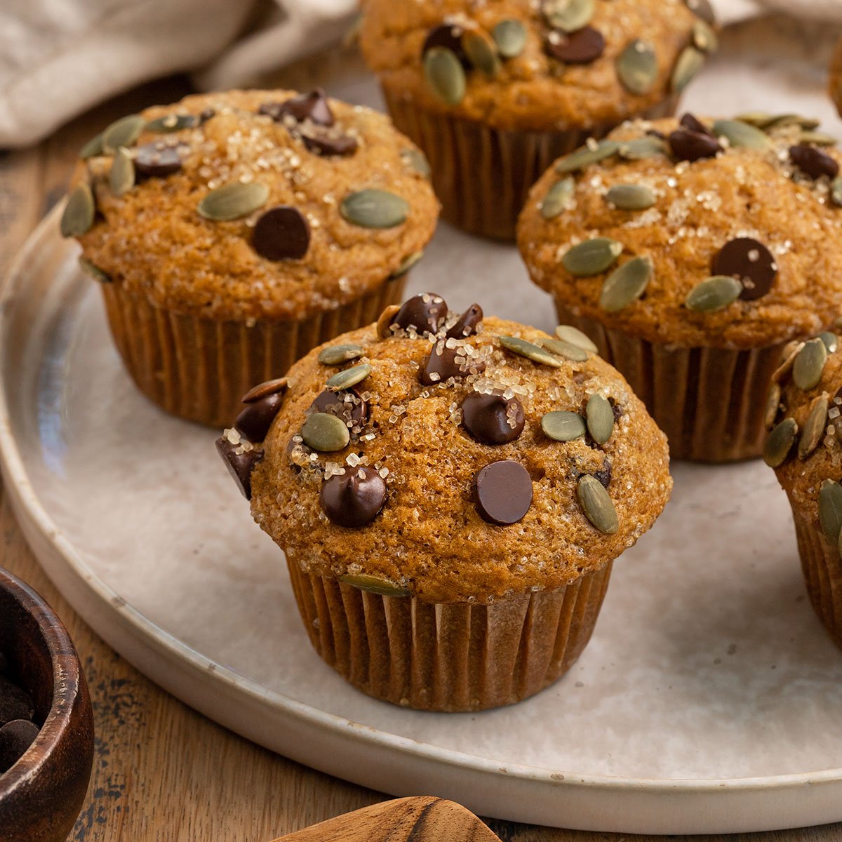 plate of pumpkin muffins with chocolate chip and pepitas.