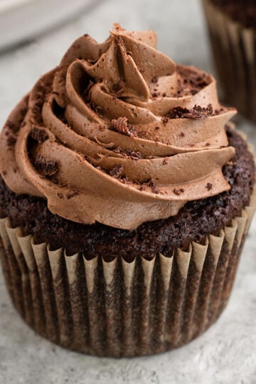 a chocolate cupcake topped with chocolate buttercream swirls and shaved chocolate.