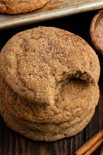 stack of maple snickerdoodles with cinnamon sugar topping with top cookie missing a bite.