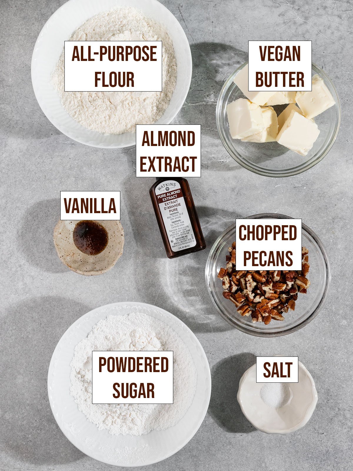 labeled ingredients including flour, butter, powdered sugar, pecans, vanilla, almond extract, and salt.