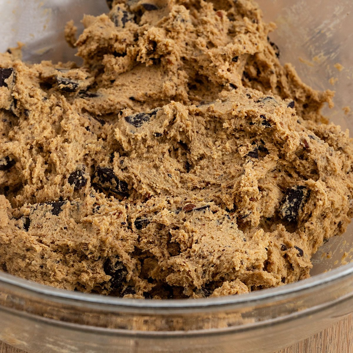 gingerbread chocolate chunk cookie dough in glass mixing bowl.