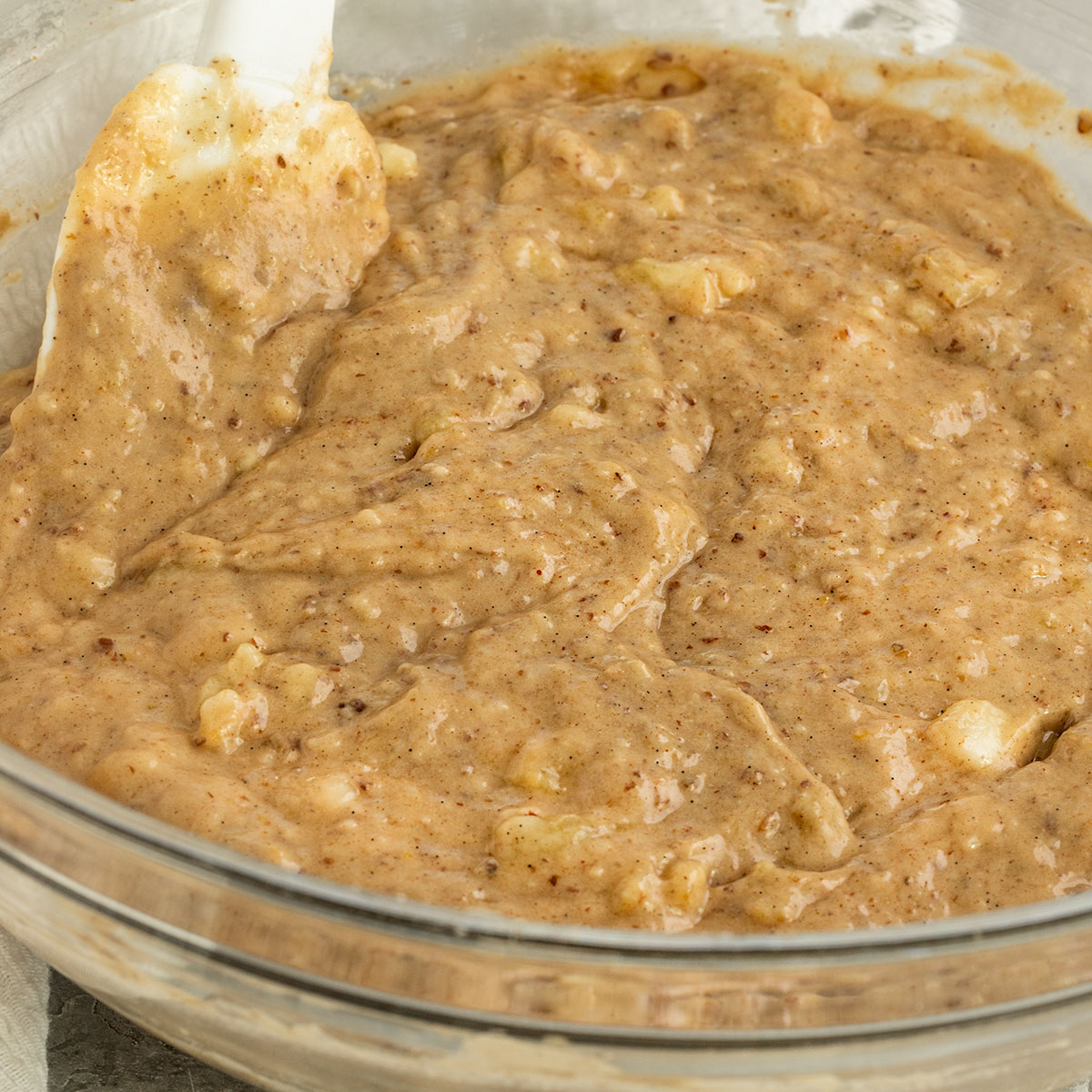 banana bread batter with spatula in a mixing bowl.