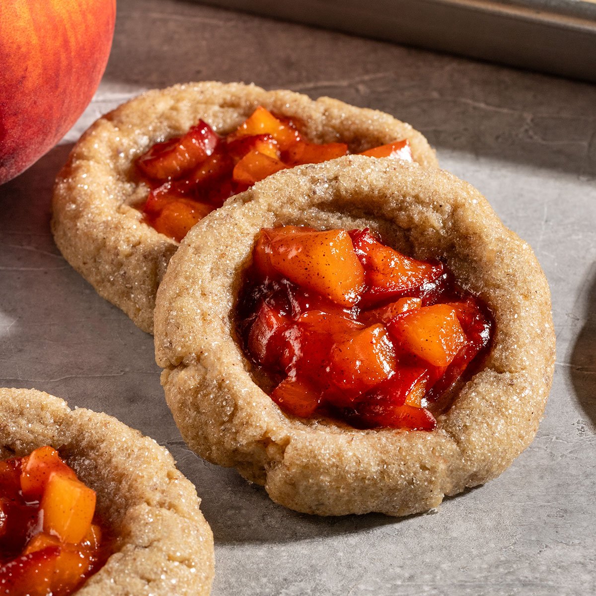 stack of cookies coated in sugar and filled with cooked peach filling.
