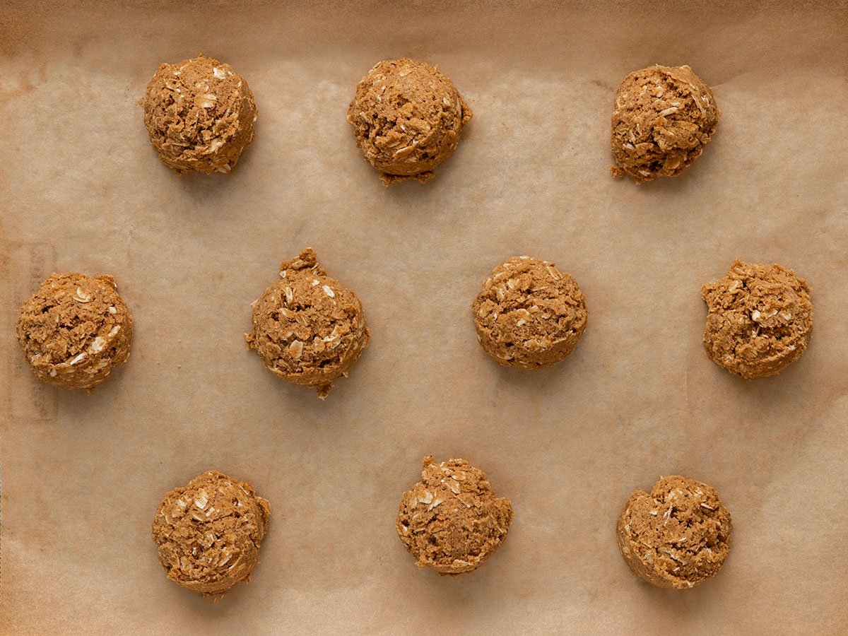cookie dough balls on a parchment lined baking tray.