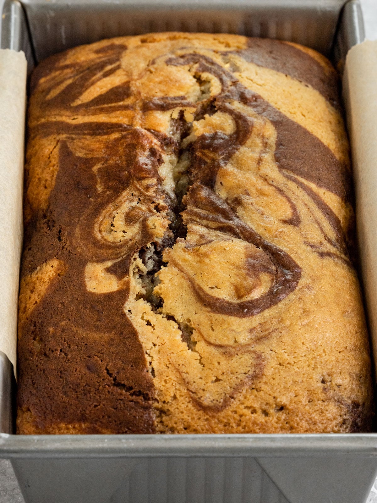 loaf pan with baked chocolate and vanilla marble cake loaf.