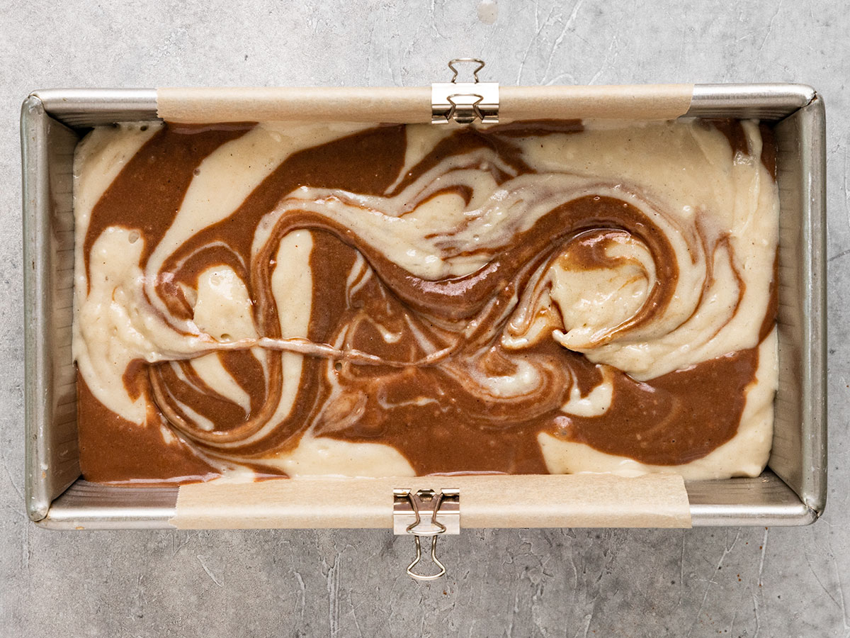 chocolate and vanilla cake batter swirled in a loaf pan.