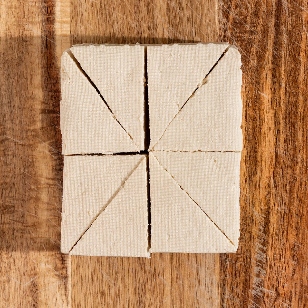 block of tofu sliced into triangles.
