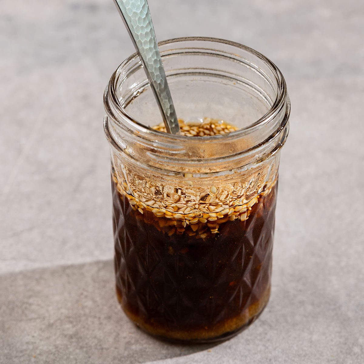 glass jar filled with a brown teriyaki sauce.