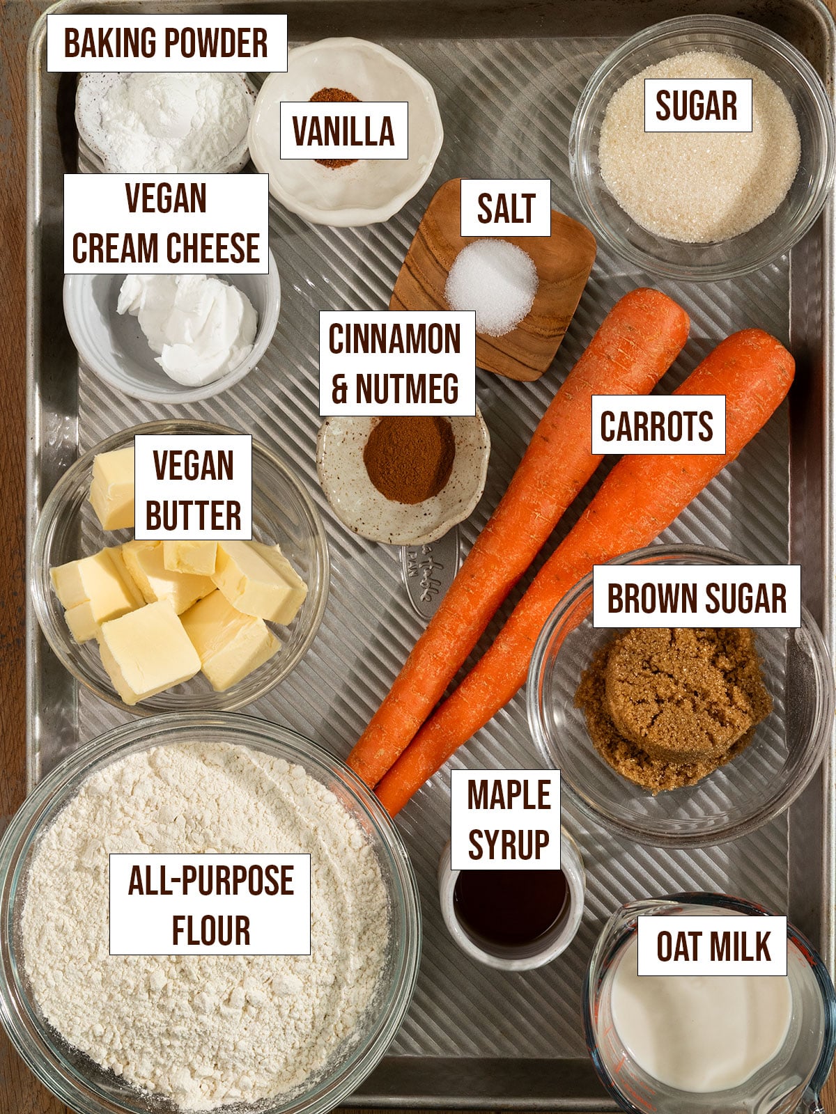 labeled ingredients for carrot cake scones on a baking tray.