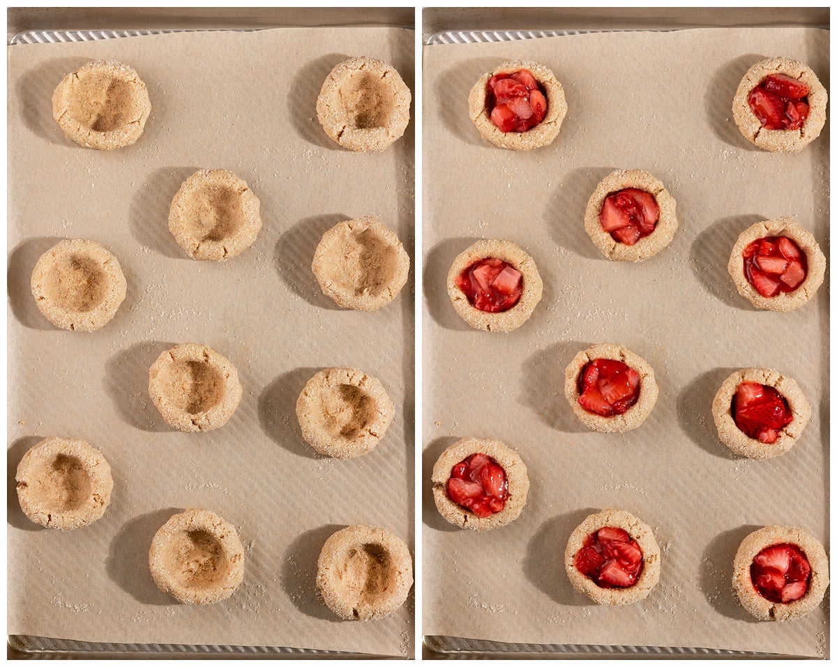 parchment lined baking tray filled with cookie dough balls with thumbprint in the middle then filled with strawberry jam.
