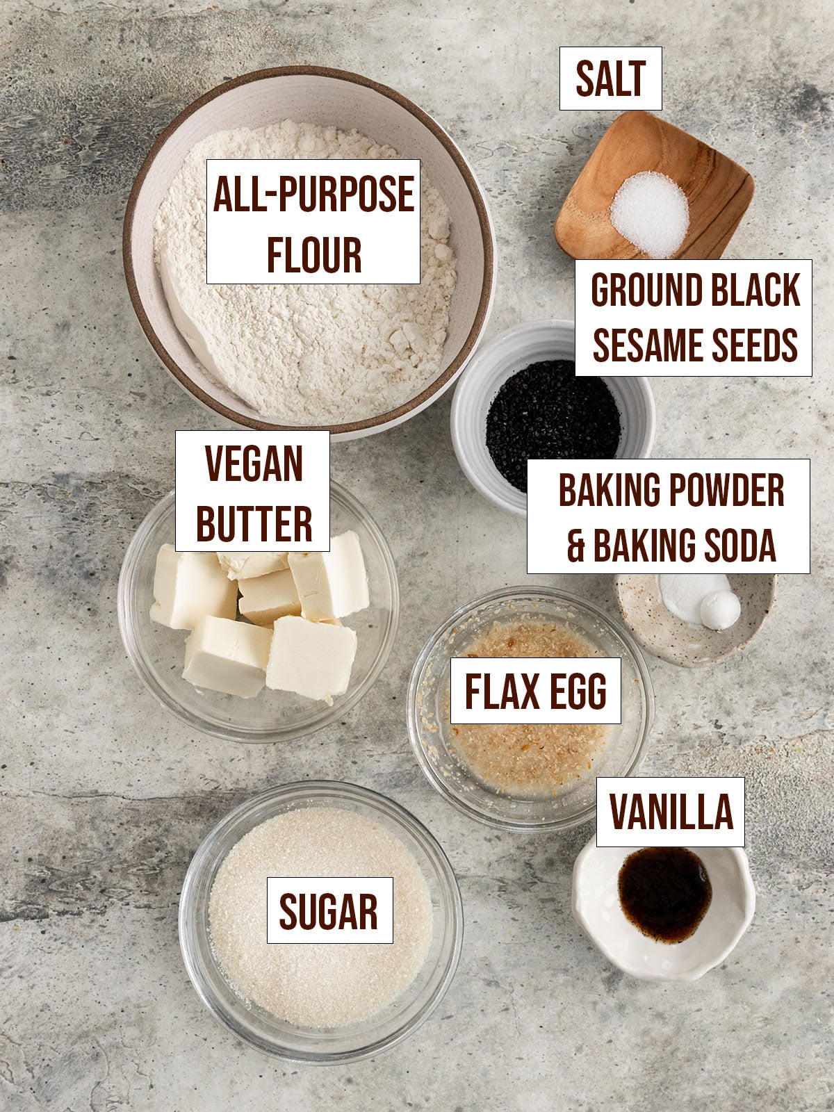 labeled ingredients for cookies including flour, sugar, baking powder, baking soda, vegan butter, flax egg, vanilla, black sesame, and sugar.