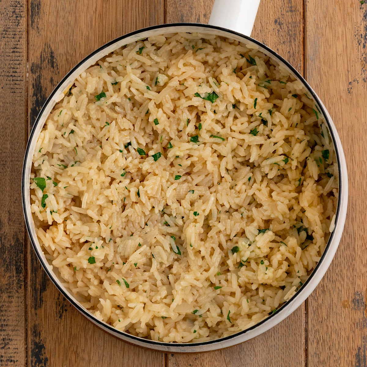 pan of cooked rice with fresh parsley.