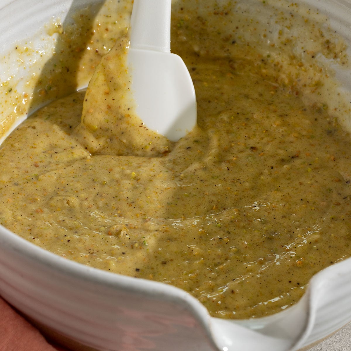 bowl of pistachio cupcake batter with spatula in it.