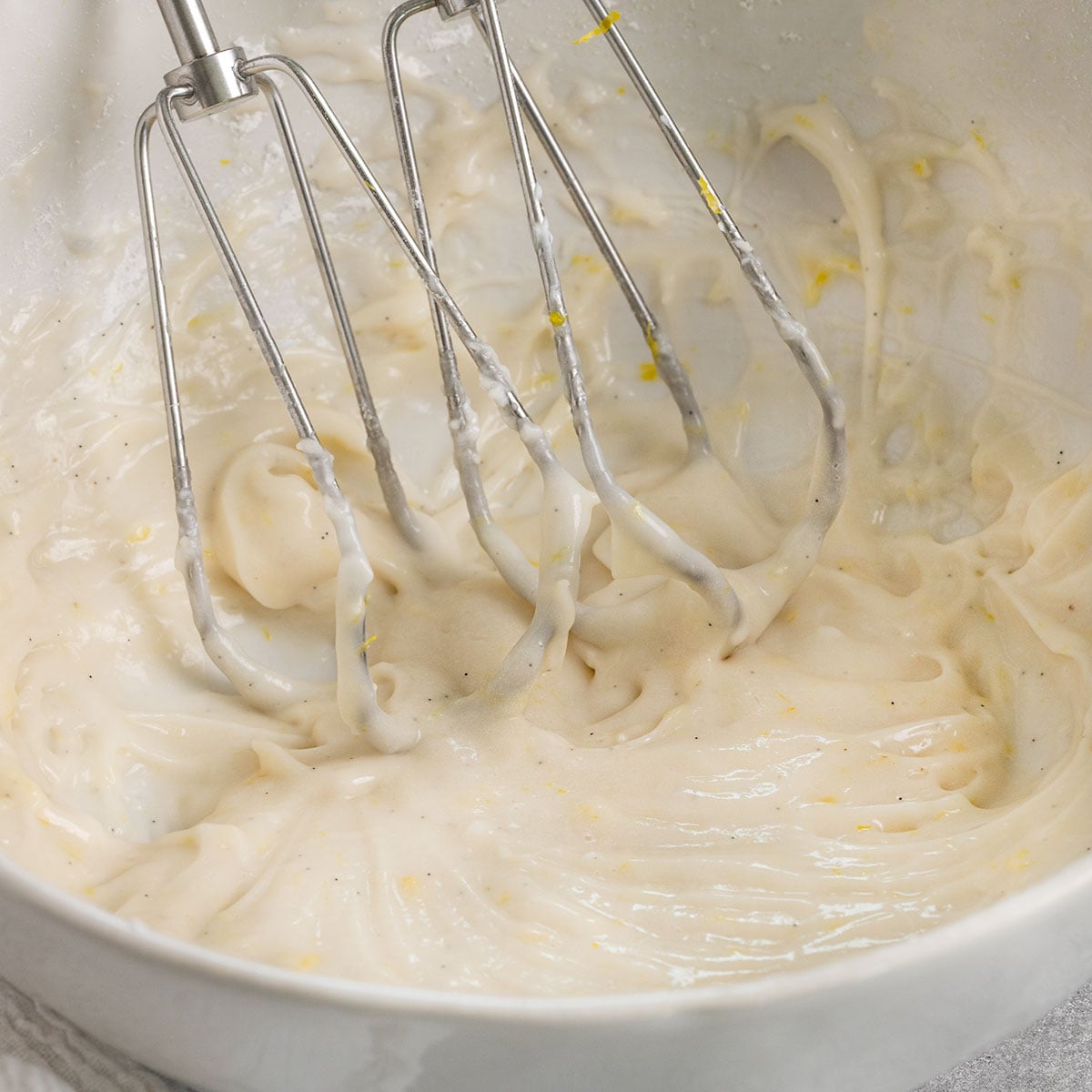 bowl of lemon cream cheese frosting with whisks inside the bowl.
