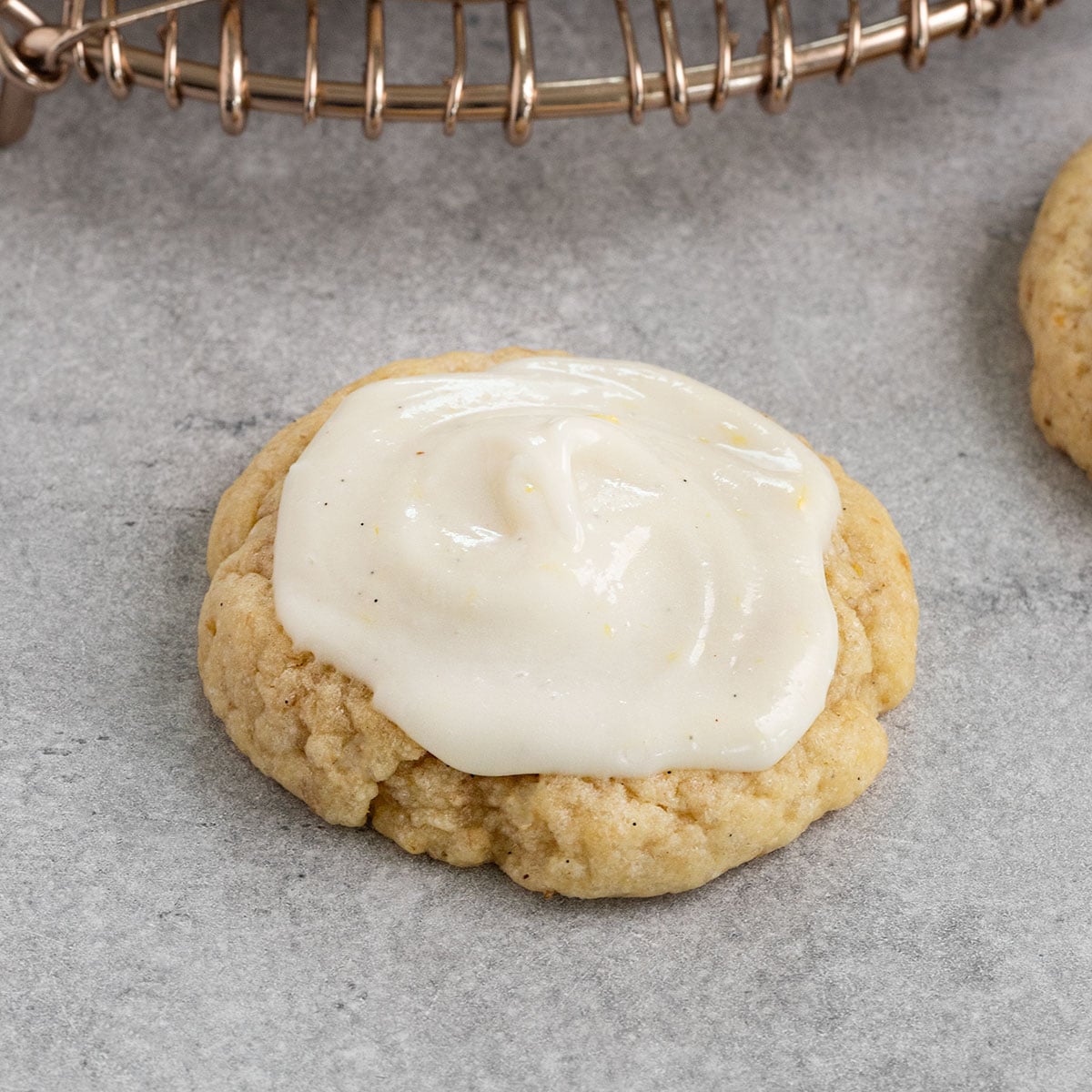 a sugar cookie topped with cream cheese frosting.