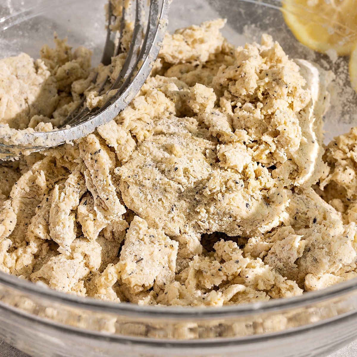 bowl of lemon earl grey scone dough with a pastry cutter in it.