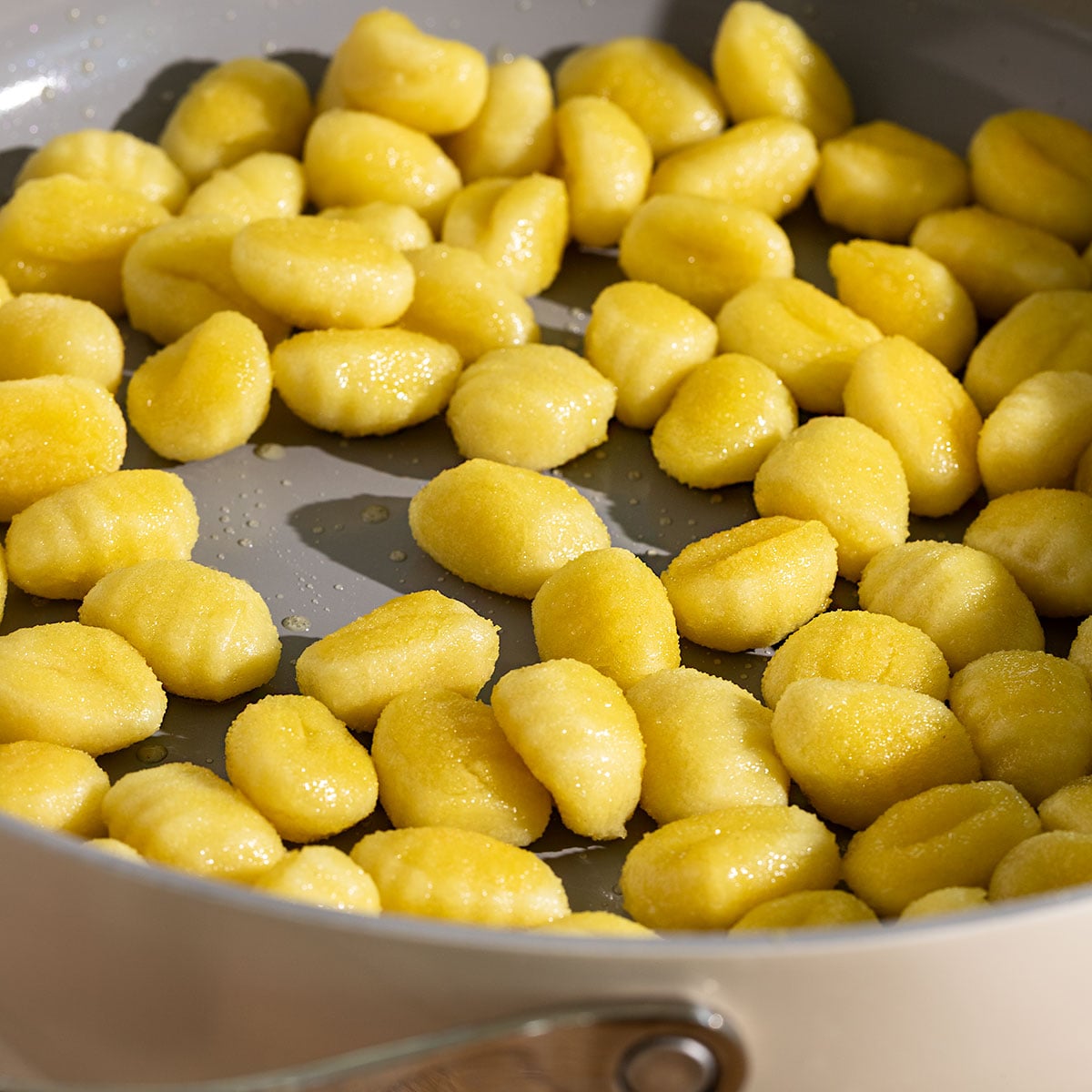 golden pan-fried gnocchi in a pan.