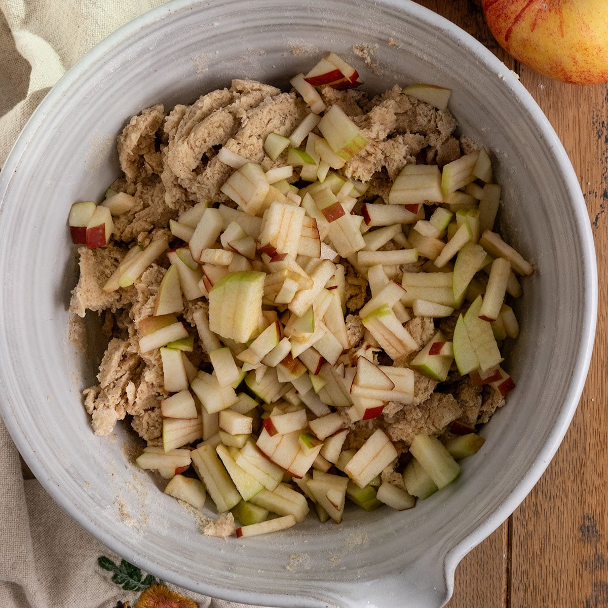 bowl of shaggy scone dough topped with finely diced apples.