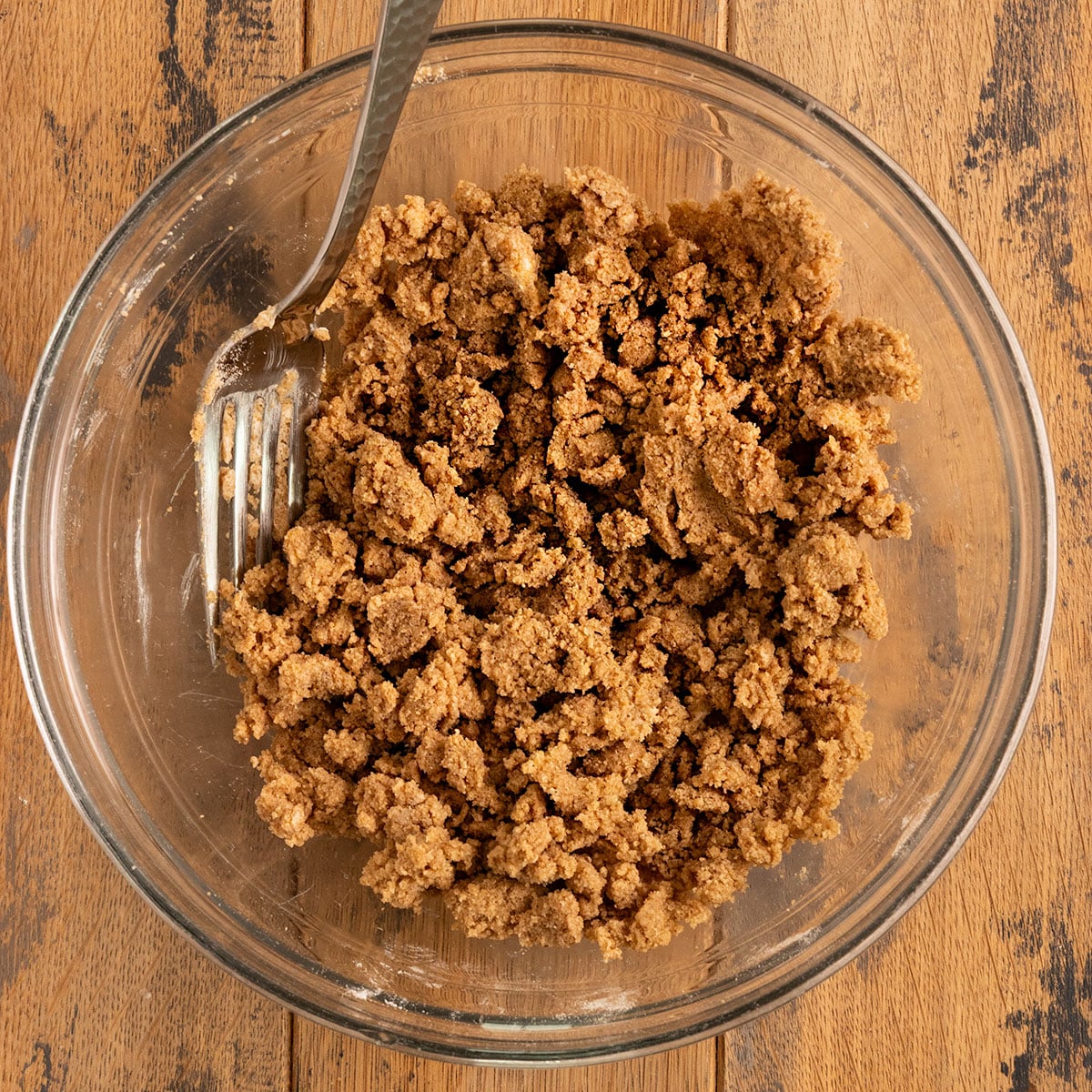 bowl of streusel mix of sugar, butter, and flour with form in bowl.