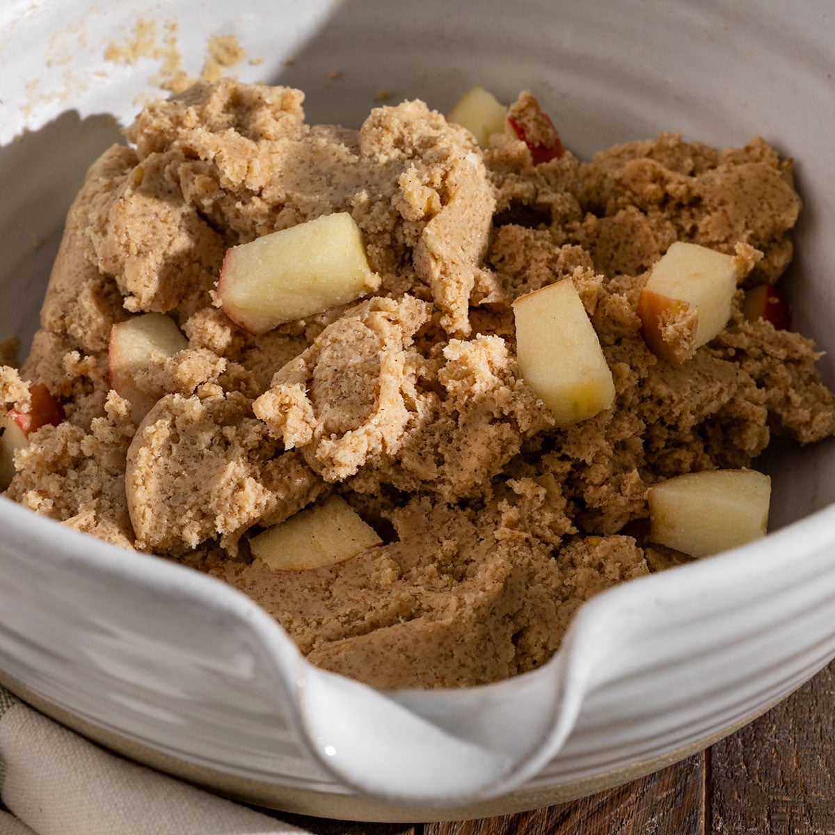 mixing bowl full of cookie dough filled with chunks of fresh apples.