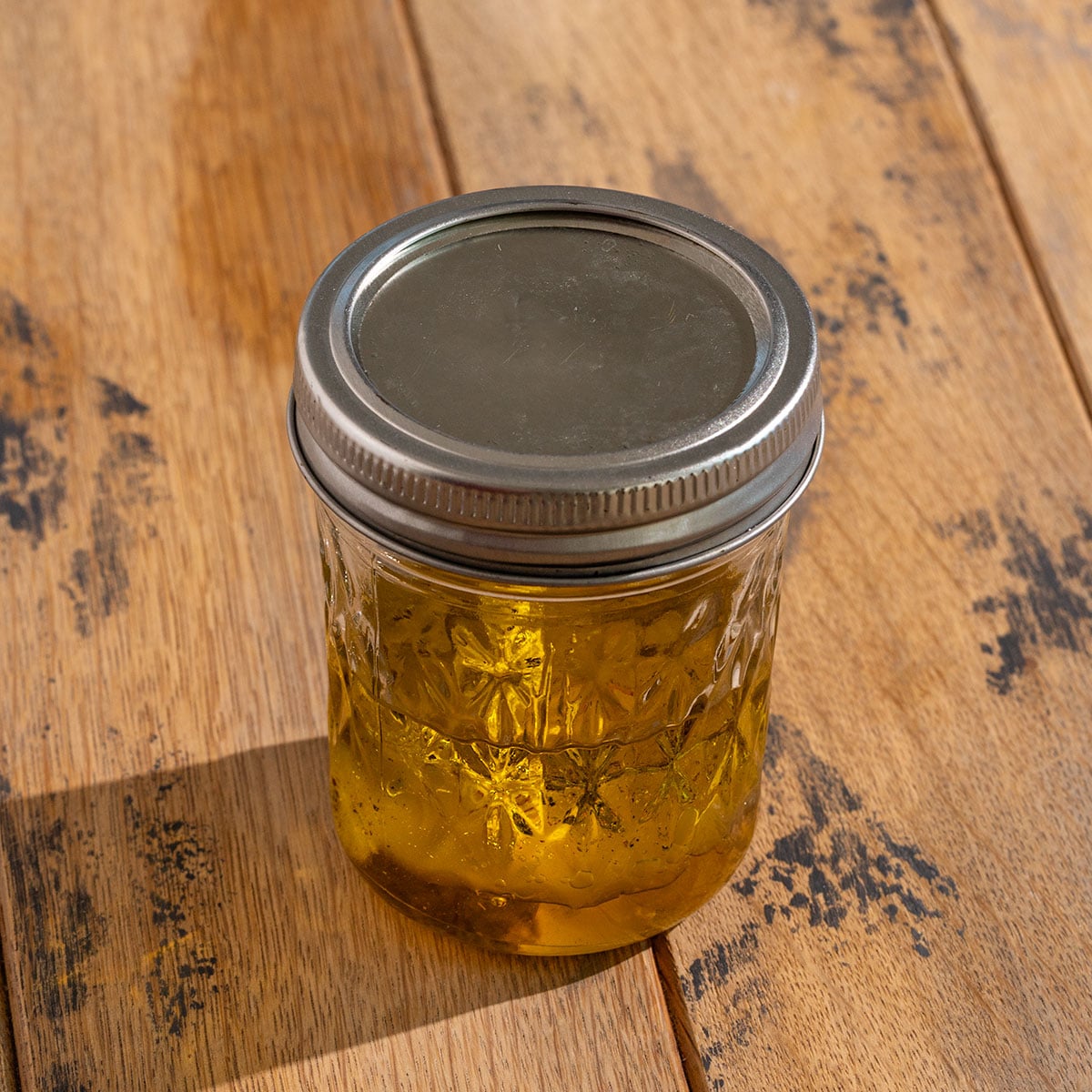 glass container filled with dressing and topped with lid.